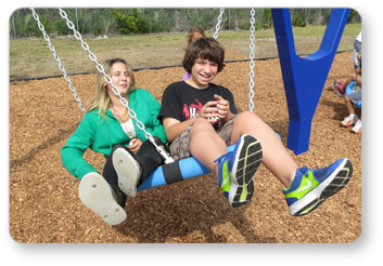 Girl and Boy Swinging on a Biggo Classic Swing