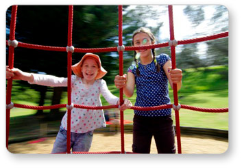 Two Girls on Rotating Climber in Motion