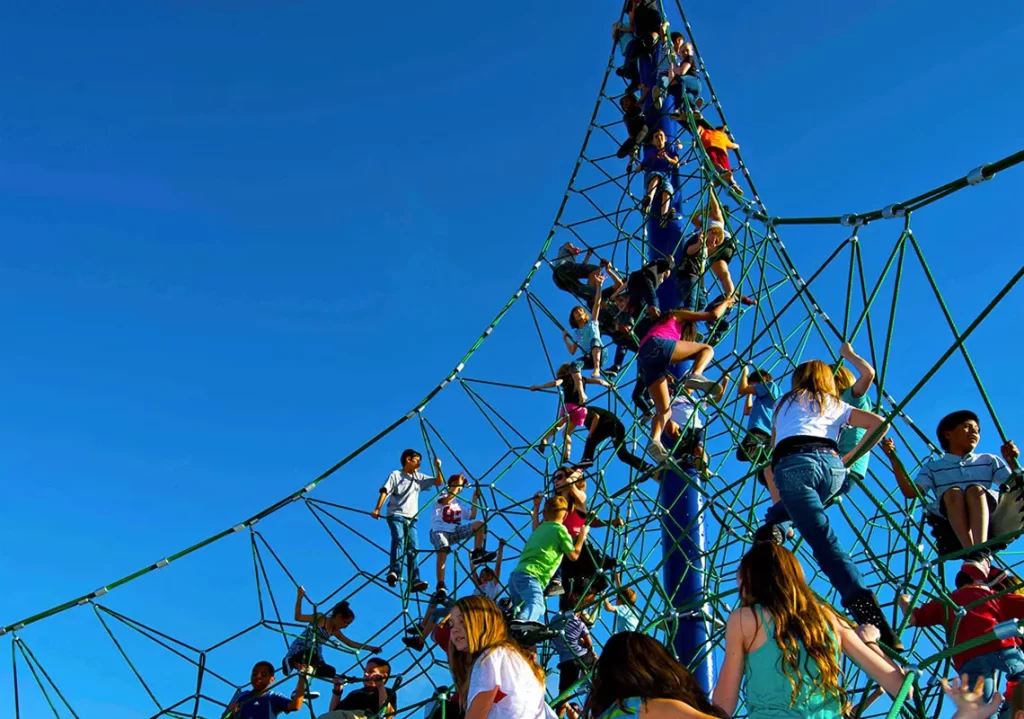 Kids climbing very tall rope pyramid